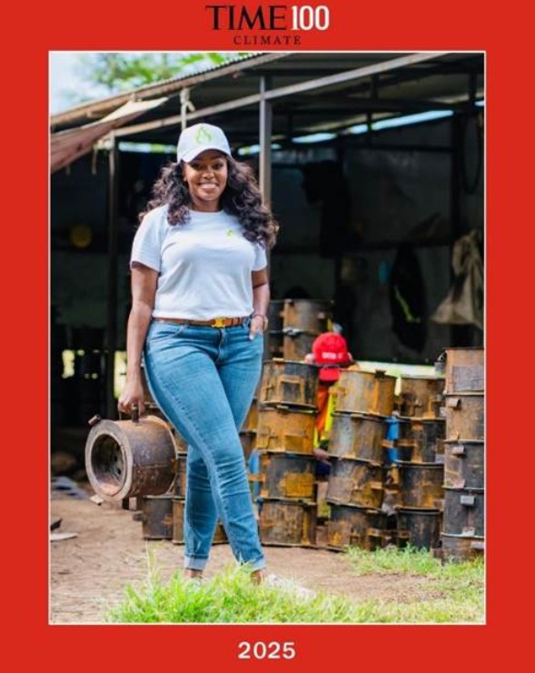 A young woman stands smiling by stacks of stove components.