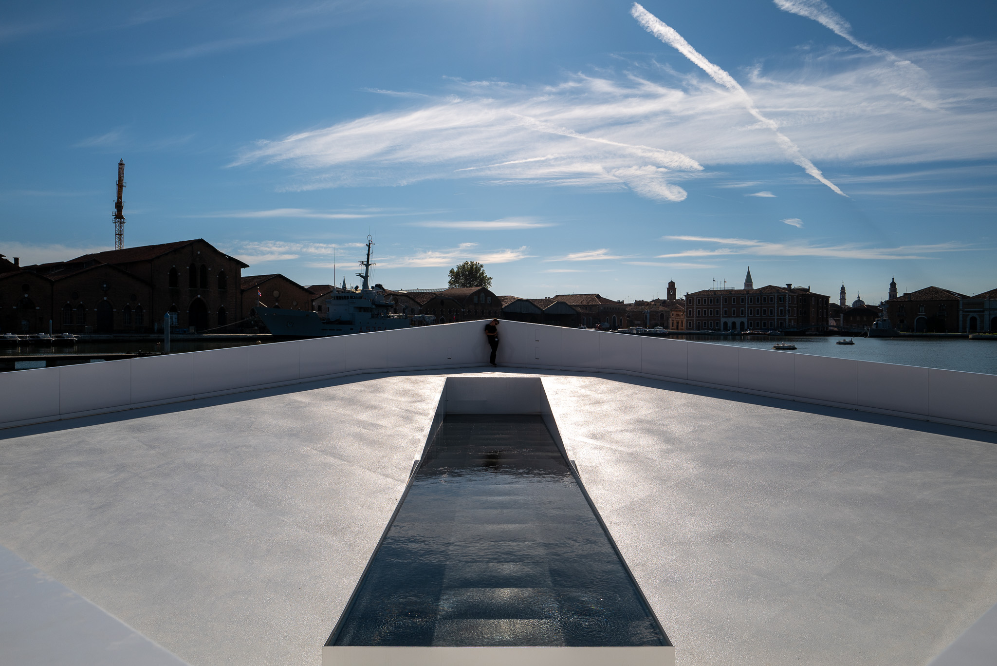 Visitors take in the crisp geometry and elegant water features of the AquaPraça floating plaza with the sun high overhead.