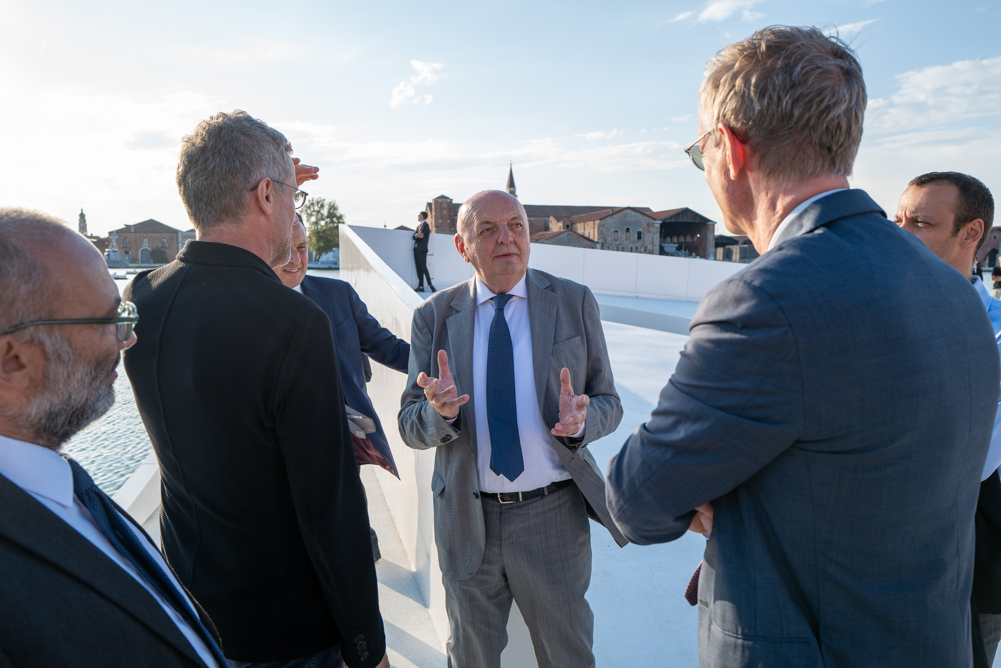 The Italian Minister of the Environment and Energy Security talks with a group of four aboard the AquaPraça floating plaza.