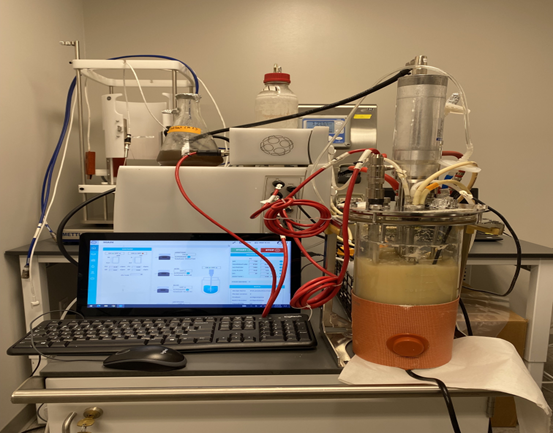 Laboratory equipment hooked up to a large horizontal monitor.