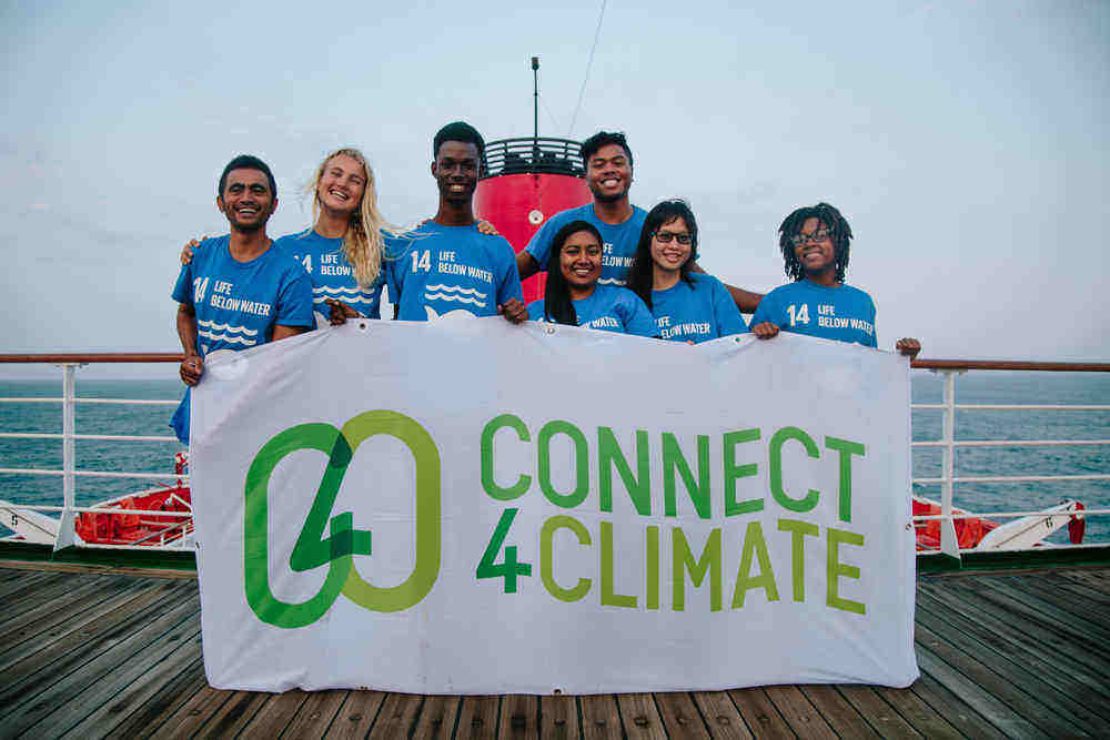 The Ocean and Climate Youth Ambassadors Programme participants took a photo with the Connect4Climate flag while on board the Peace Boat.